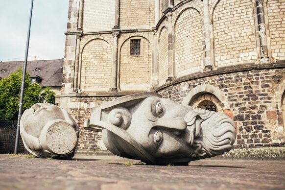 Die Steinköpfe von Cassius (links) und Florentius vor dem Bonner Münster