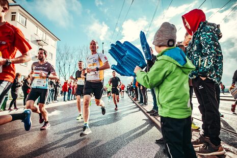 Marathonläufer an der Kennedybrücke werden von Fans angefeuert