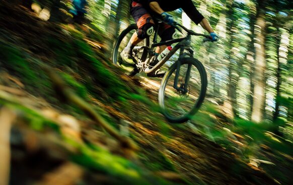 Ein Mann fährt mit einem Mountainbike durch den Wald.