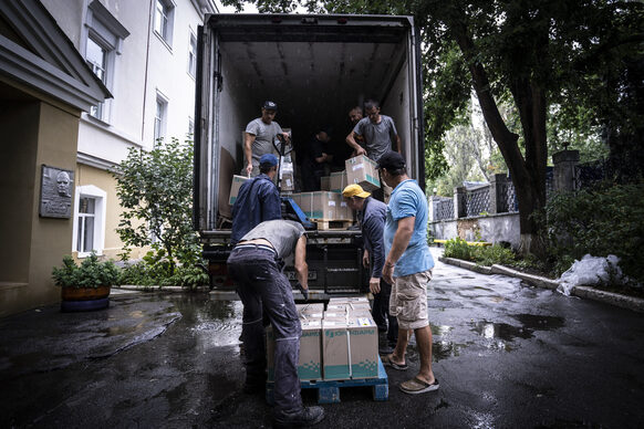 Mehrere Männer laden Pakete aus einem Lkw aus