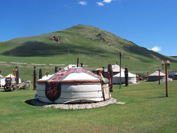 Jurten auf einer Wiese in der Mongolei