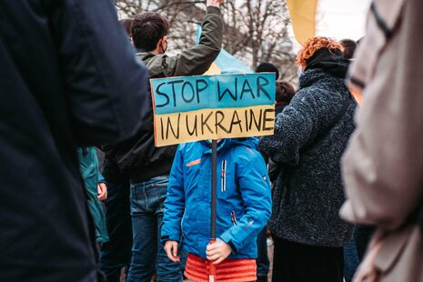 Ein Kind hält bei einer Kundgebung ein Schild hoch Stop war in Ukraine