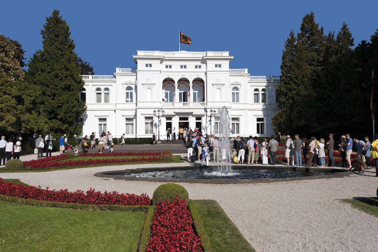 Menschen stehen vor der Villa Hammerschmidt und warten auf Einlass