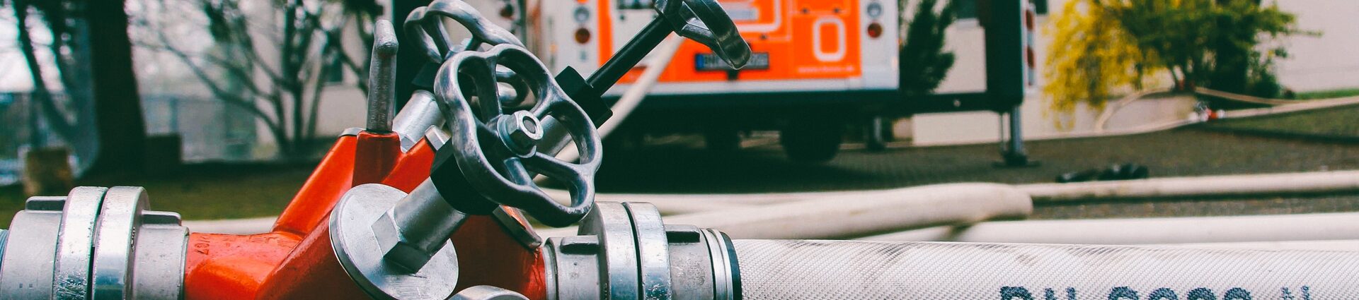 Feuerwehrfahrzeug und Wasseschlauch an Hydrant.