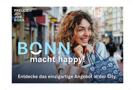 Eine sich freuende Frau mit Einkaufstüten in der Bonner City