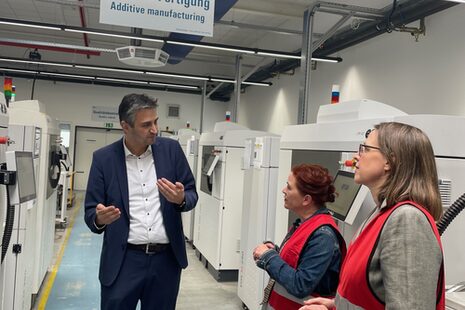 Уміт Айдін з GKN у розмові з мером Катею Дьорнер та бізнес-промоутером Вікторією Аппельбе; машини на задньому плані.