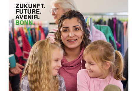 Eine Frau und zwei Kinder, die vor ihr sitzen