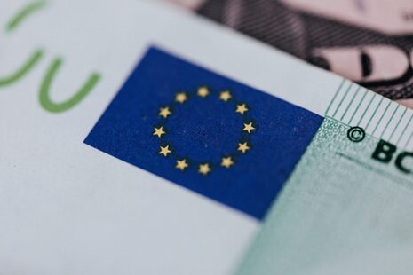 Euro banknotu üzerinde mavi zemin üzerinde sarı yıldızların bulunduğu Avrupa bayrağının yakın çekimi