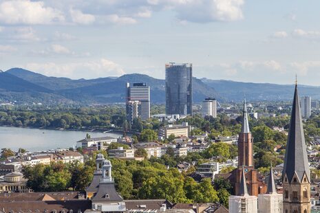 Blick vom Stadthausdach auf die Bonner Innenstadt. Im Hintergrund sind Posttower, UN-Tower und Siebengebirge.