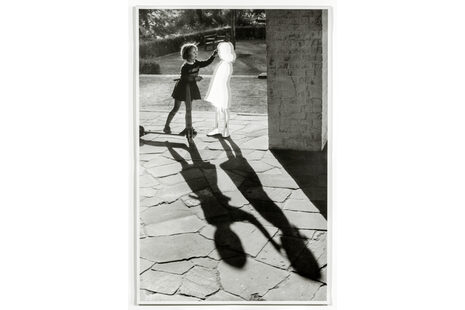 Die schwarz-weiß Fotografie zeigt ein Mädchen mit einem Umriss und zwei Schatten